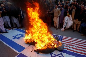 People chant slogans as they burn an effigy of U.S. President Donald Trump on the U.S. and Israel's flags during a protest over the death of Iranian Major-General Qassem Soleimani, who was killed in an air strike near Baghdad, in Peshawar, Pakistan January 10, 2020. REUTERS/Fayaz Aziz