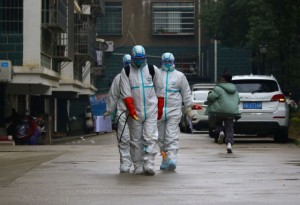 Workers from local disease control and prevention department in protective suits disinfect a residential area following the outbreak of a new coronavirus, in Ruichang, Jiangxi province, China January 25, 2020. Picture taken January 25, 2020. cnsphoto via REUTERS. ATTENTION EDITORS - THIS IMAGE WAS PROVIDED BY A THIRD PARTY. CHINA OUT.