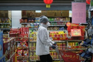 A woman wearing a face mask looks for goods at a supermarket, as the country is hit by an outbreak of the new coronavirus, in Beijing, China January 26, 2020. REUTERS/Carlos Garcia Rawlins