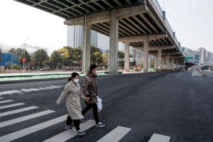 People wear face masks as they cross an empty main street in Changsha, Hunan province, China, as the country is hit by an outbreak of a new coronavirus, January 29, 2020. REUTERS/Thomas Peter
