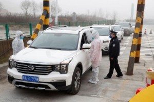 Medical workers in protective suits check the body temperature of car passengers at a checkpoint outside the city of Yueyang, Hunan Province, near the border to Hubei Province that is on lockdown after an outbreak of a new coronavirus, China, January 28, 2020. REUTERS/Thomas Peter