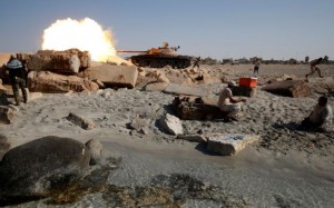 A fighter of Libyan forces allied with the U.N.-backed government fires a shell with Soviet made T-55 tank at Islamic State fighters from a beach in Sirte, Libya, August 3, 2016. REUTERS/Goran Tomasevic