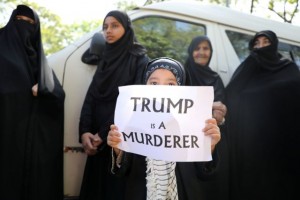 A girl holds a sign reading “Trump is a murderer” during a condolence ceremony for Iranian Major-General Qassem Soleimani, who was killed in a airstrike near Baghdad, outside the Embassy of Iran in Kuala Lumpur, Malaysia, January 7, 2020. REUTERS/Lim Huey Teng