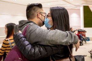 Travellers embrace while wearing masks at Pearson airport arrivals, shortly after Toronto Public Health received notification of Canada's first presumptive confirmed case of coronavirus, in Mississauga, Greater Toronto Area, Ontario, Canada January 26, 2020. REUTERS/Carlos Osorio