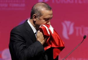 FILE PHOTO: Turkey's President Tayyip Erdogan kisses a handmade Turkish flag, given to him as a gift from Ugandan university student Cemil (not pictured), during a graduation ceremony in Ankara, Turkey, June 11, 2015. REUTERS/Umit Bektas/File Photo