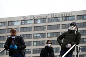 Men wearing protective face masks outside St Thomas' Hospital, near Westminster as the number of coronavirus cases grow around the world. London, Britain, March 17, 2020. REUTERS/Hannah McKay