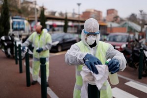 Workers clean street furnitures with disinfectant in front of the train station near the hospital to slow the rate of the coronavirus disease (COVID-19) in Suresnes, near Paris, France, March 20, 2020. REUTERS/Christian Hartmann