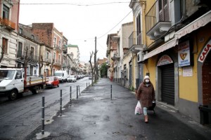 A woman wearing a protective face mask, following the outbreak of the coronavirus disease (COVID-19), walks on an almost empty street in Catania, Italy April 2, 2020. REUTERS/Antonio Parrinello