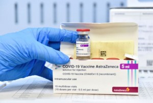 FILE PHOTO: A healthcare worker shows a vial and a box of the AstraZeneca coronavirus disease (COVID-19) vaccine, as vaccinations resume after a brief pause in their use over concern for possible connection to blood clots, in Turin, Italy, March 19, 2021. REUTERS/Massimo Pinca/File Photo
